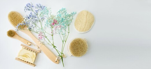 On a light background, natural wooden accessories for spa and beauty treatments, organic handmade soap, delicate flowers.  Flat lay, top view, space for text.  Concept ecology, zero waste, eco style.