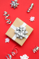 Gift box with bows and serpentine on red background
