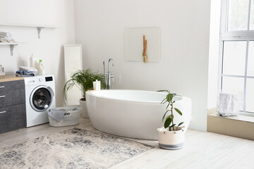 Interior of bathroom with bathtub, houseplants and pegboard © Pixel-Shot