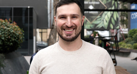 Obraz premium Young bearded man smiling outdoor. 