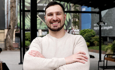 Young bearded man smiling outdoor. 