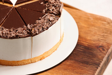 Wooden board with tasty birds milk cake, closeup