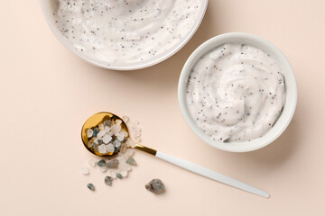 Bowl of natural body scrub and sea salt on color background