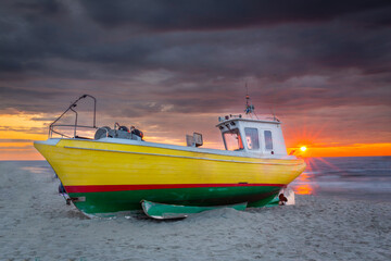 Naklejka na ściany i meble Fishing vessel against the backdrop of a beautiful sunset