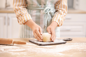 Woman preparing dough for pasta at table in kitchen, closeup