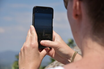 Blick über die Schulter einer Person, während diese mit einem Smartphone die Natur fotografiert