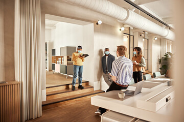 Diverse businesspeople wearing masks at work
