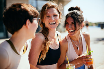 Three friends laughing outside after yoga