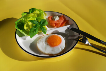close up of ketogenic breakfast with fried egg, green salad and smoked salmon