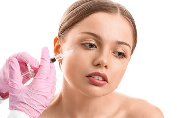 Fototapeta premium Young woman receiving filler injection in face against white background