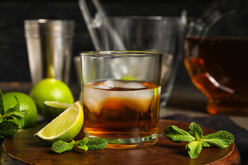 Glass of rum with ice, mint and lime on table