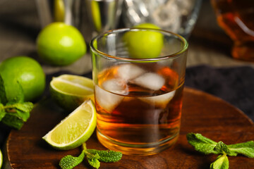 Glass of rum with ice, mint and lime on table