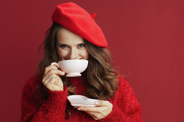 happy elegant woman in red sweater and beret with tea cup