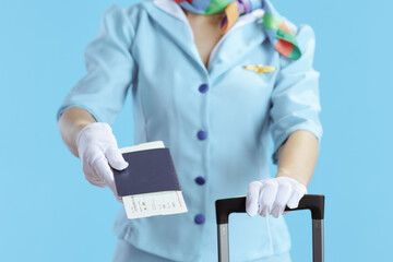 Closeup on stylish female flight attendant on blue