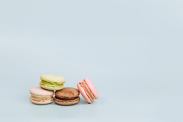 Sweet macaroons in pastel colors isolated on blue background. Delicious beautiful macaroons.