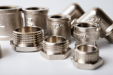 brass metal plugs, joints, adapters, hex key plugs for water isolated on light background close up plumbing connections and parts
