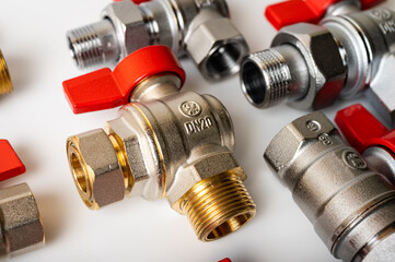 brass, metal water faucets with red valve, different, isolated on light background close-up, plumbing connection 