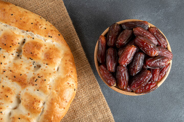 Date fruits with Ramadan pita on black background