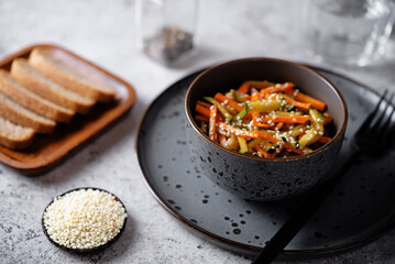 Asian cucumber carrot salad with sesame seeds in a bowl