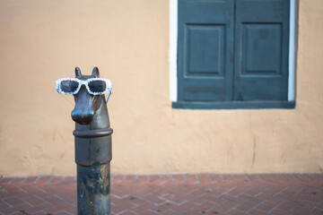 Ornate horse hitching post in the French Quarter of New Orleans, with sunglasses on for Mardi Gras - Left aligned and copy space