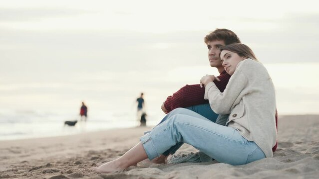 Video of beautiful young couple in love enjoying the day in a cold winter on the beach.