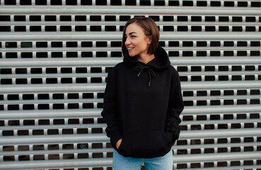 Handsome young female wearing black blank hoodie with space for your logo or design. Mockup for...