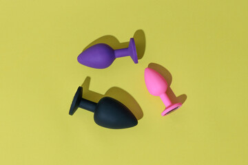 Different colored buttplug sex toys with contrast shadows. Anal toys for adult. Sex shop concept
