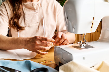 Seamstress basting and sewing in a small studio. Sartorial clothes. Fashion studio, tailoring,...