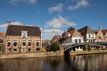 Fototapeta na wymiar Bontebrug bridge at the turfmarkt with waterside residential houses on the edge of the river kleindiep waterway in Dokkum, Friesland, Netherlands Holland on sunny day. 