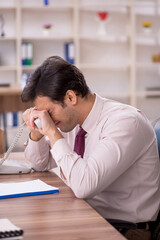 Young male employee and too much work in the office