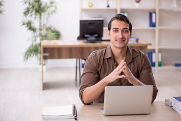 Young attractive employee sitting in the office