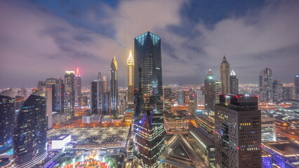 Panorama of futuristic skyscrapers after sunset in financial district business center in Dubai day to night timelapse