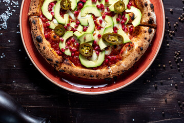 Pizza with avacado, jalapeno and pomegranate seeds