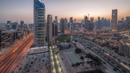 Naklejka na ściany i meble Dubai's business bay towers aerial day to night timelapse. Rooftop view of some skyscrapers