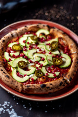 Pizza with avacado, jalapeno and pomegranate seeds