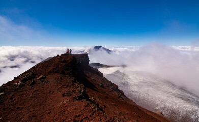 Vista del volcán Tolhuaca y montañistas amigos entre las Nubes desde la cumbre del volcán Lonquimay, region de la Araucanía, Chile