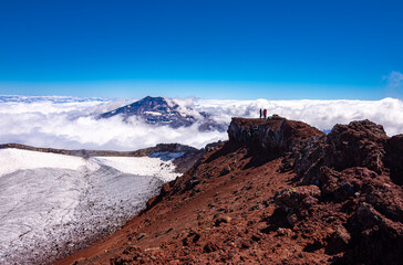 fotografia panoramica Vista del volcán Tolhuaca y montañistas entre las Nubes desde la cumbre del volcán Lonquimay, region de la Araucanía, Chile