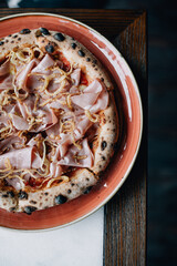 pizza on a plate with bacon and cheese