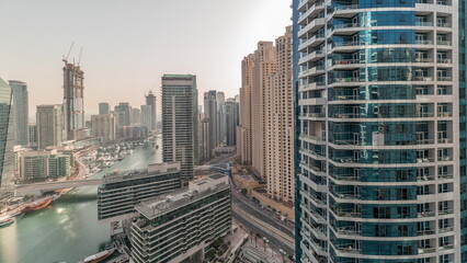 Panorama showing overview to JBR and Dubai Marina skyline with modern high rise skyscrapers waterfront living apartments aerial timelapse - obrazy, fototapety, plakaty