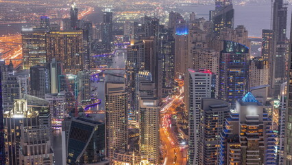Skyline view of Dubai Marina showing canal surrounded by skyscrapers along shoreline day to night timelapse. DUBAI, UAE