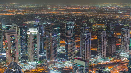 Dubai marina towers with traffic on Sheikh Zayed road near metro station night timelapse.