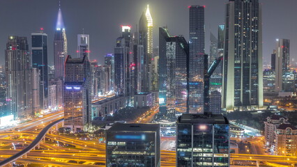 Panorama of Dubai Financial Center district with tall skyscrapers illuminated all night timelapse.
