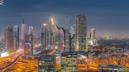Fototapeta na wymiar Panorama of Dubai Financial Center district with tall skyscrapers with illumination day to night timelapse.