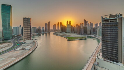 Sunset cityscape of skyscrapers in Dubai Business Bay with water canal aerial timelapse
