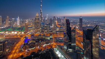 Naklejka premium Aerial view of tallest towers in Dubai Downtown skyline and highway day to night timelapse.
