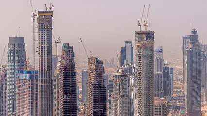 Naklejka premium Dubai downtown with large-scale construction of a residential complex with a view of construction cranes aerial timelapse