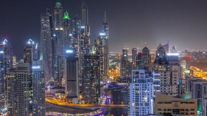 Fototapeta premium View of various skyscrapers in tallest recidential block in Dubai Marina aerial all night timelapse