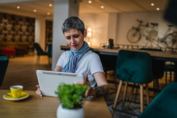 Fototapeta premium One woman mature adult senior female use digital tablet at cafe
