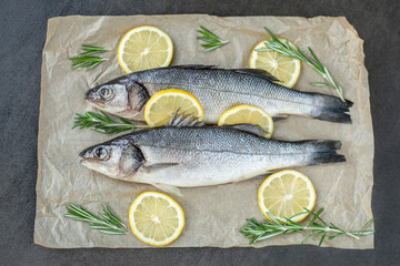 Fresh fish with spices and herbs on table in kitchen. Fresh sea bass.