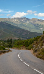 Fototapeta na wymiar Route qui passe au milieu des montagnes en Corse